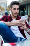 Young Entrepreneur Using His Mobile Phone At Coffee Shop Stock Photo