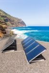 Rows Of Solar Collectors On Roof At Beach And Sea Stock Photo