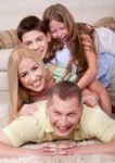 Portrait Of Happy Family Lying On Top Of Each Other Stock Photo