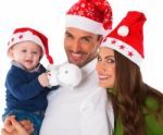 Happy Parents With Baby Boy Wearing Santa Hats Stock Photo