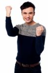 Excited Young Guy With Clenched Fists Stock Photo