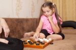Girl Playing Draughts With Her Mother Stock Photo