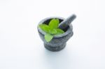 Stone Mortar And Pestle With Peppermint Leaf On White Wooden Bac Stock Photo
