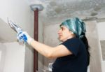 Young Woman Geting Plaster Wall Stock Photo