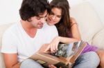 Couple Looking At Album Stock Photo