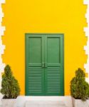 Green Door On Yellow Wall Stock Photo