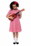 Preschool Cute Girl Playing A Guitar Stock Photo