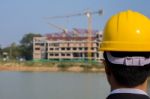 Businessman Looking At Building With Crane Stock Photo
