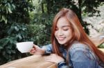 Happy Young Woman Drinking Coffee Outdoors And Using Smartphone Stock Photo