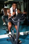 Muscular Man On Excercise Bike At The Gym Stock Photo
