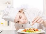 Young Chef Decorating Delicious Salad Stock Photo