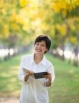 Portrait Of Young Asian Woman And Book In Hand Rising Hand As Victory With Happiness Face Emotion Use For People Success In Education And Business Stock Photo