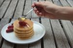 Spoon Pouring Honey On Pancakes Stock Photo