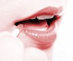 Girl Applying Lip Gloss To Her Lips Stock Photo