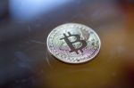 Bitcoin Curency Coin On Glass Table Stock Photo