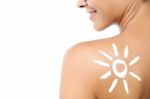 Woman With Sunscreen Lotion On Her Back Stock Photo