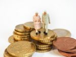 Miniature Senior Couple Stand On Pile Of Euro Coins. Retirement Stock Photo