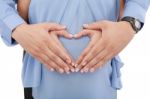 Hands Of Pregnant Woman And Her Husband In Heart Shape Stock Photo
