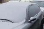 Parked Car Covered With The First Snow In Winter Stock Photo