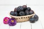 Tasty Purple Plums Isolated On A White Wooden Background Stock Photo