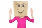 Woman Wearing Paper Bag With Happy Facial Expression On Head Stock Photo