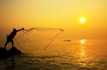 Throwing Fishing Net During Sunrise Stock Photo