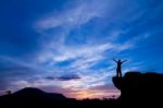 Silhouette Of A Man On The Rock At Sunset Stock Photo