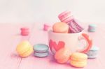 French Macarons In Cup On Pink Wooden Background.toned Image Stock Photo