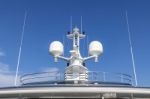 Communication Antennas With Navigation Equipment, Radar On The Upper Deck Of The Luxury White Cruise Ship.  There Is A Thai Flag With Clear Blue Sky In The Sunny Day Stock Photo
