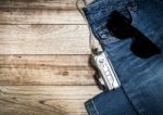 Jeans, Sunglasses And Digital Camera On Wooden Plank Stock Photo