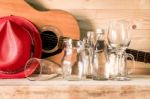 Acoustic Guitar And Assorted Glass Bottles On Wooden Table. Retr Stock Photo