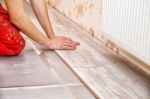 Young Handyman Installing Wooden Floor Stock Photo