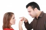Young Couple Pointing At Each Other Against A White Background Stock Photo