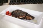 Rib-eye Steak Resting On The Plate In The Kitchen Ready To Serve Stock Photo