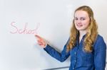 Dutch Teenage Girl Pointing At Word School Written On White Boar Stock Photo