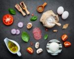 The Ingredients For Homemade Pizza On Dark Stone Background Stock Photo