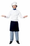 Male Chef In Uniform Welcoming Guests Stock Photo