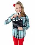 Smiling Girl Holding Clapperboard Stock Photo