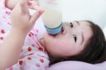 Closeup Cute Asian Girl Suck Up Milk Bottle. Drinking Milk For Good Healthy Stock Photo