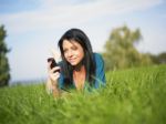 Young Woman Using Mobile Phone In Park Stock Photo