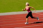 Athletic Woman Running On Track Stock Photo