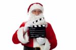 Cheerful Aged Santa Posing With A Clapperboard Stock Photo