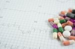 Heap Of Medicine Pills On Cardiogram Grid Paper. Selective Focus Stock Photo