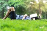Mature Man Sleeping On Green Grass In City Park  With A Book Cov Stock Photo