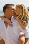 Couples Kissing At Beach Stock Photo