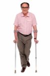 Senior Man Walking With Crutches Stock Photo