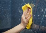 Female Hand Washes The Tile On The Wall With A Cloth Lather Stock Photo