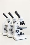 Three Microscopes In A Row Isolated On Background Stock Photo