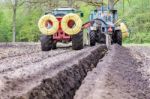 Two Agriculture Tractors Putting Drainage Pipes In Ground Stock Photo