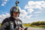 Elderly Man Motorcyclist In Protective Helmet Looking At Smartph Stock Photo